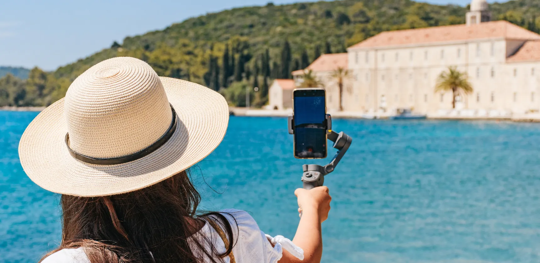Creadora de contenido grabando junto al mar — estilo de vida UGC travel creator