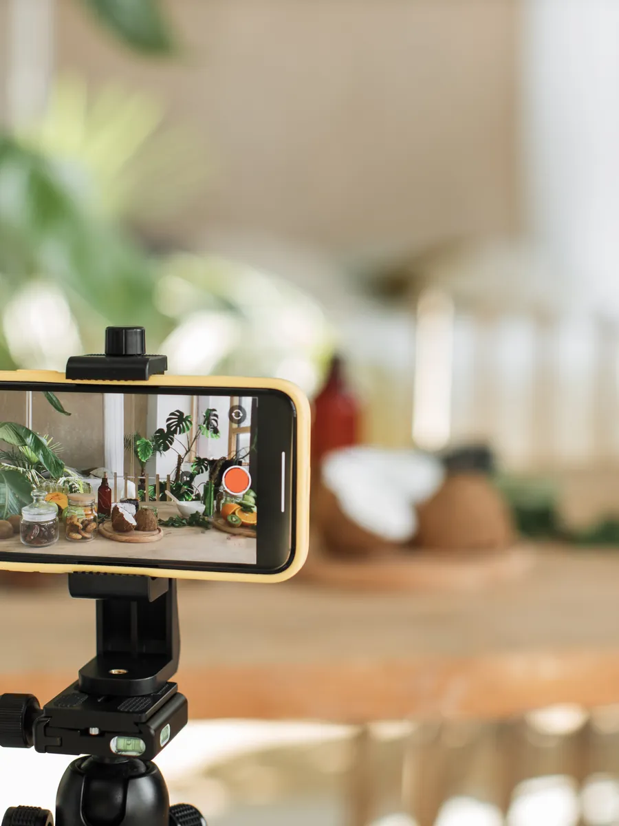 Teléfono en trípode grabando una mesa preparada en un hotel